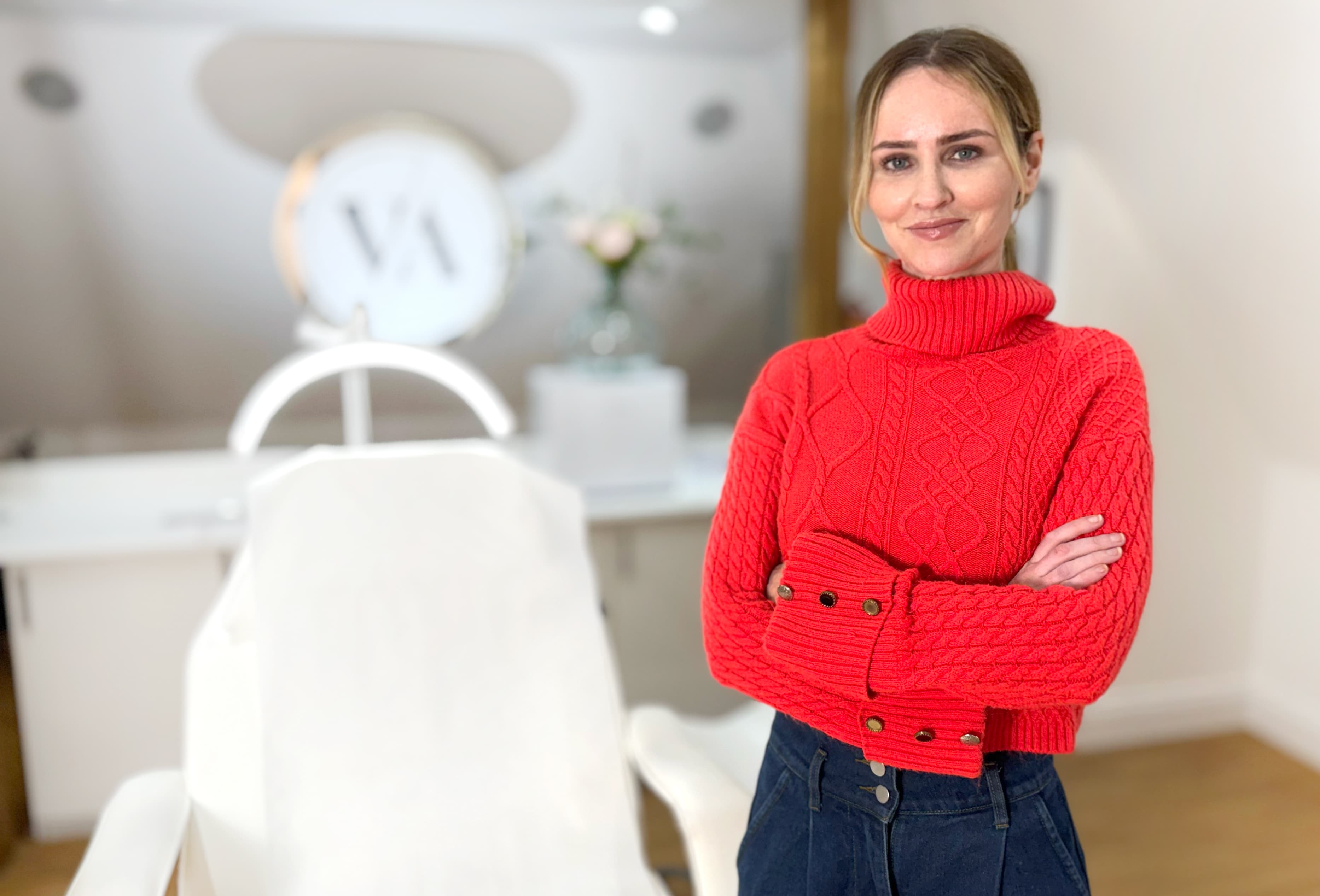 Bernadette Tobin RN MSc, arms folded, in her treatment room at Visage Aesthetics.