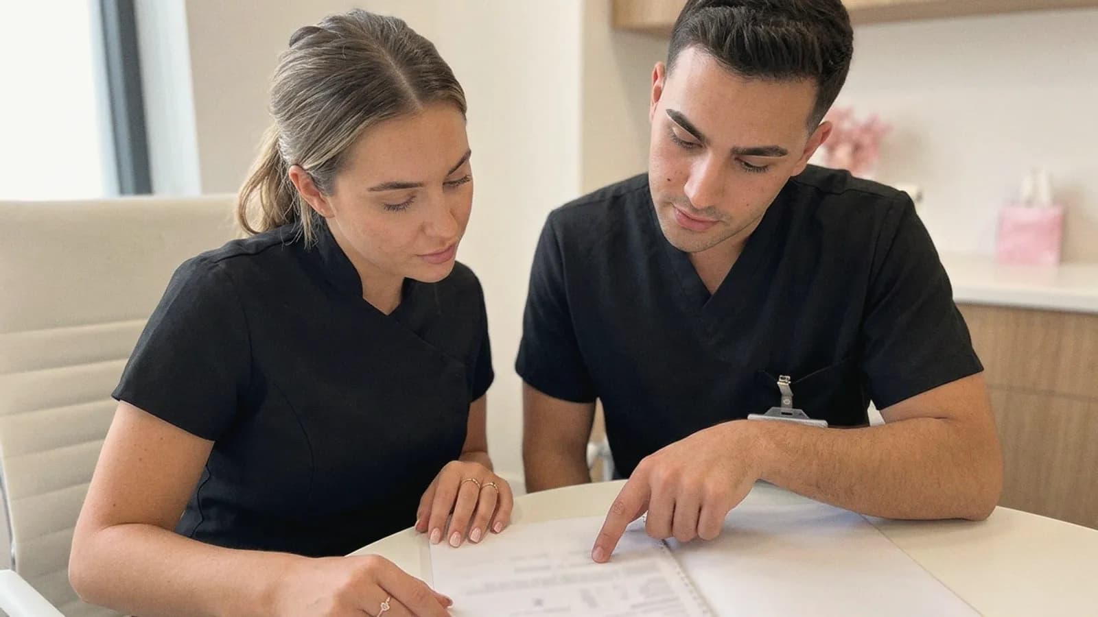 Two practitioners read through a client record together.