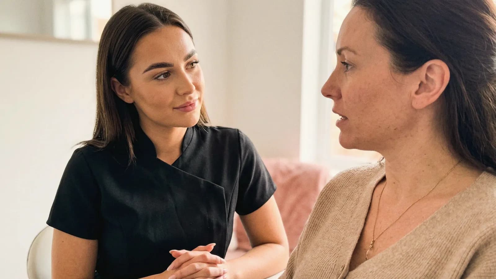 A practitioner listens closely to a client during a face-to-face consultation.